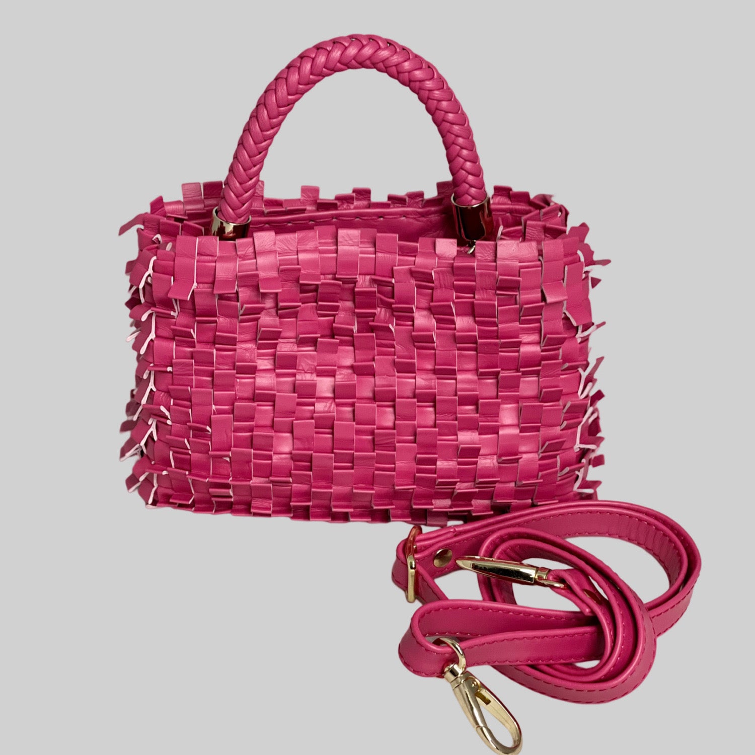 Den rosa Ribimini-vesken kombinerer flettede plissédesign med avtagbar skulderstropp og robuste håndtak, alle med gullfargede detaljer, for et snev av luksus.