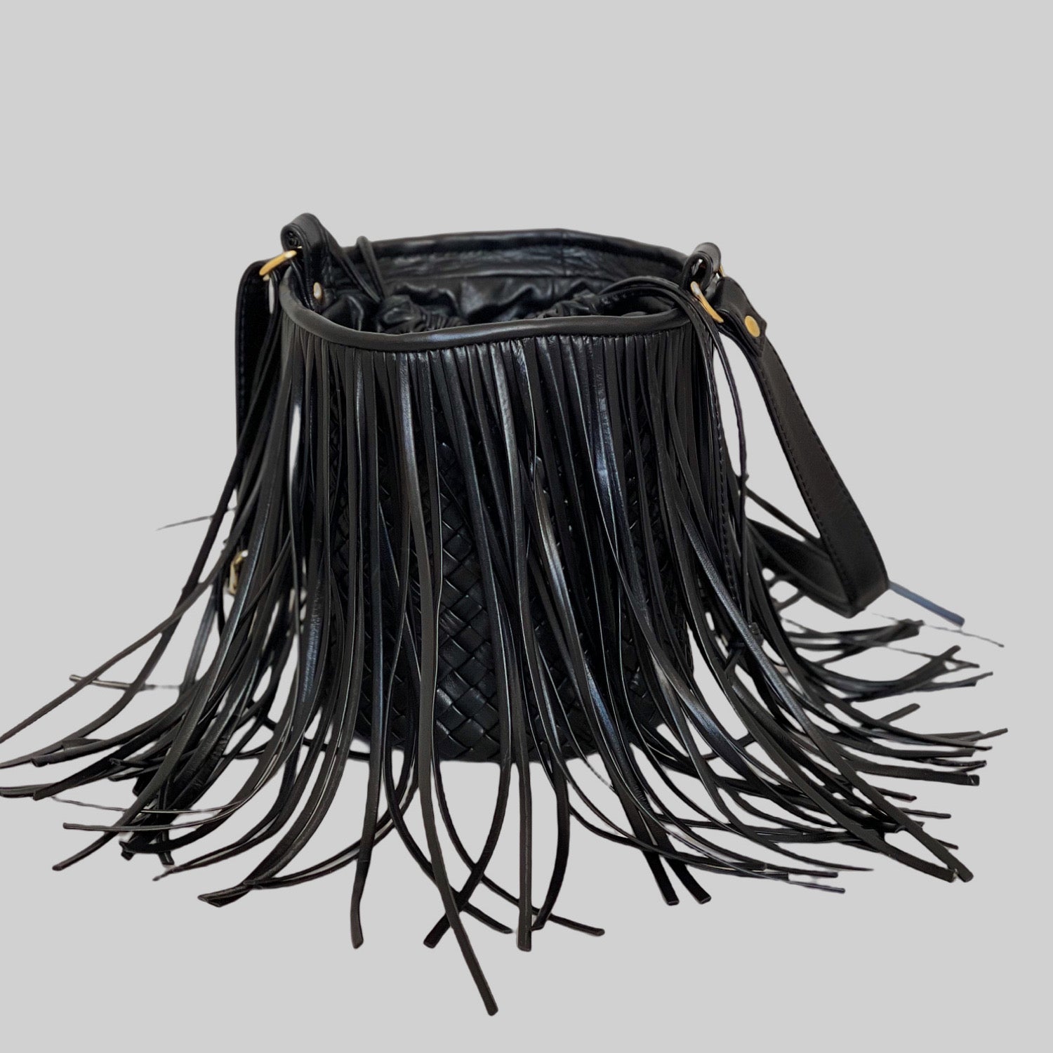 Ribichini Bucket i sort med frekke frynser og glitrende gulldetaljer tiltrekker misunnelige blikk med sin ikoniske bucket-form.